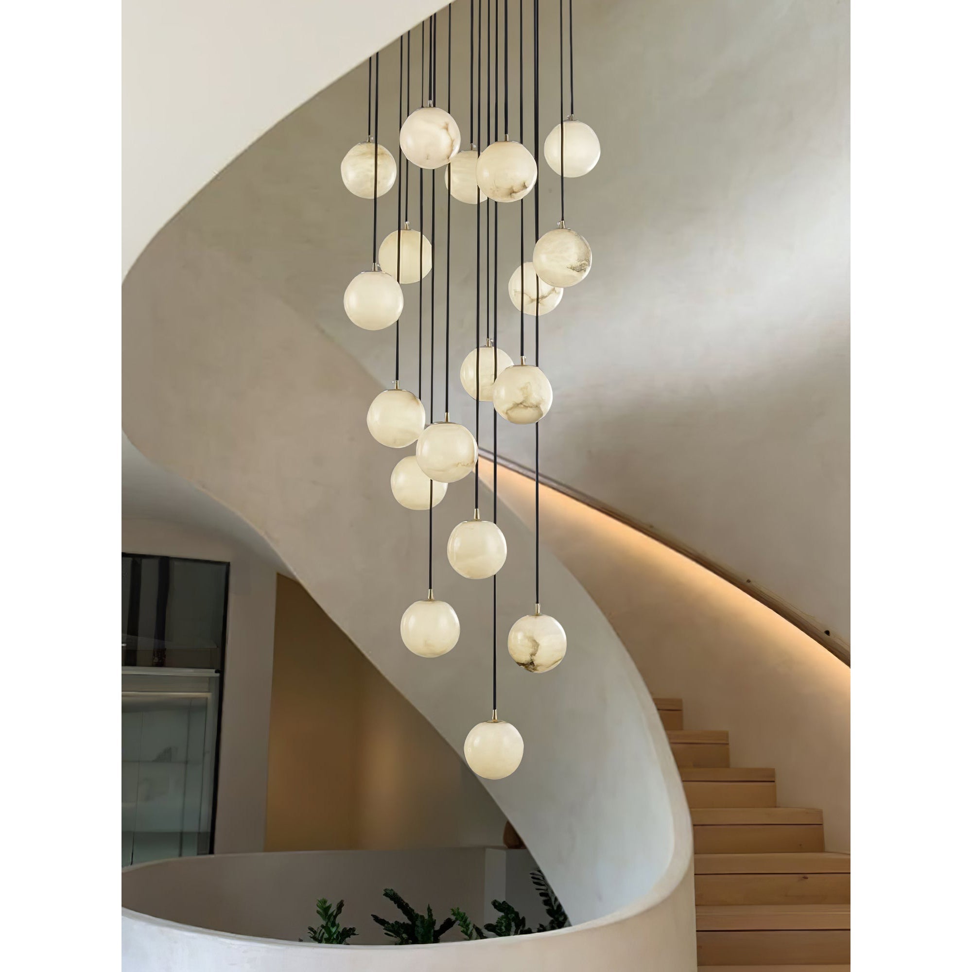 Alabaster balls cascading down a sculpted plaster stairwell, with planting at the foot.