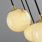 Close-up of one alabaster ball and its brushed brass cap, stone veining clearly visible.