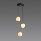 The three-ball Afralia alabaster chandelier, its spheres staggered down black cords on grey.