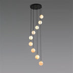 Nine alabaster balls of the Afralia chandelier, warm veining visible through the stone.