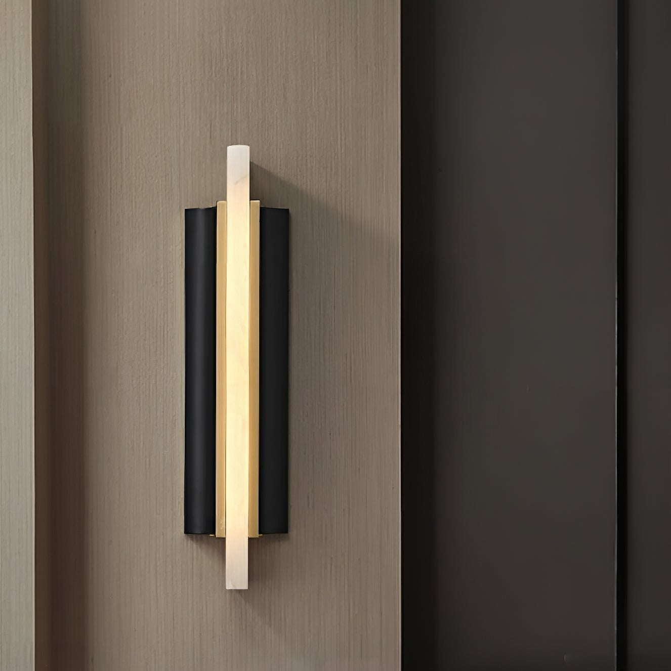 Side-angle view of the Aurelian sconce on wood panelling, showing the brass channel behind the stone blade