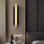 The light lit on a wood-panelled bedroom wall, above a nightstand with a figurine.
