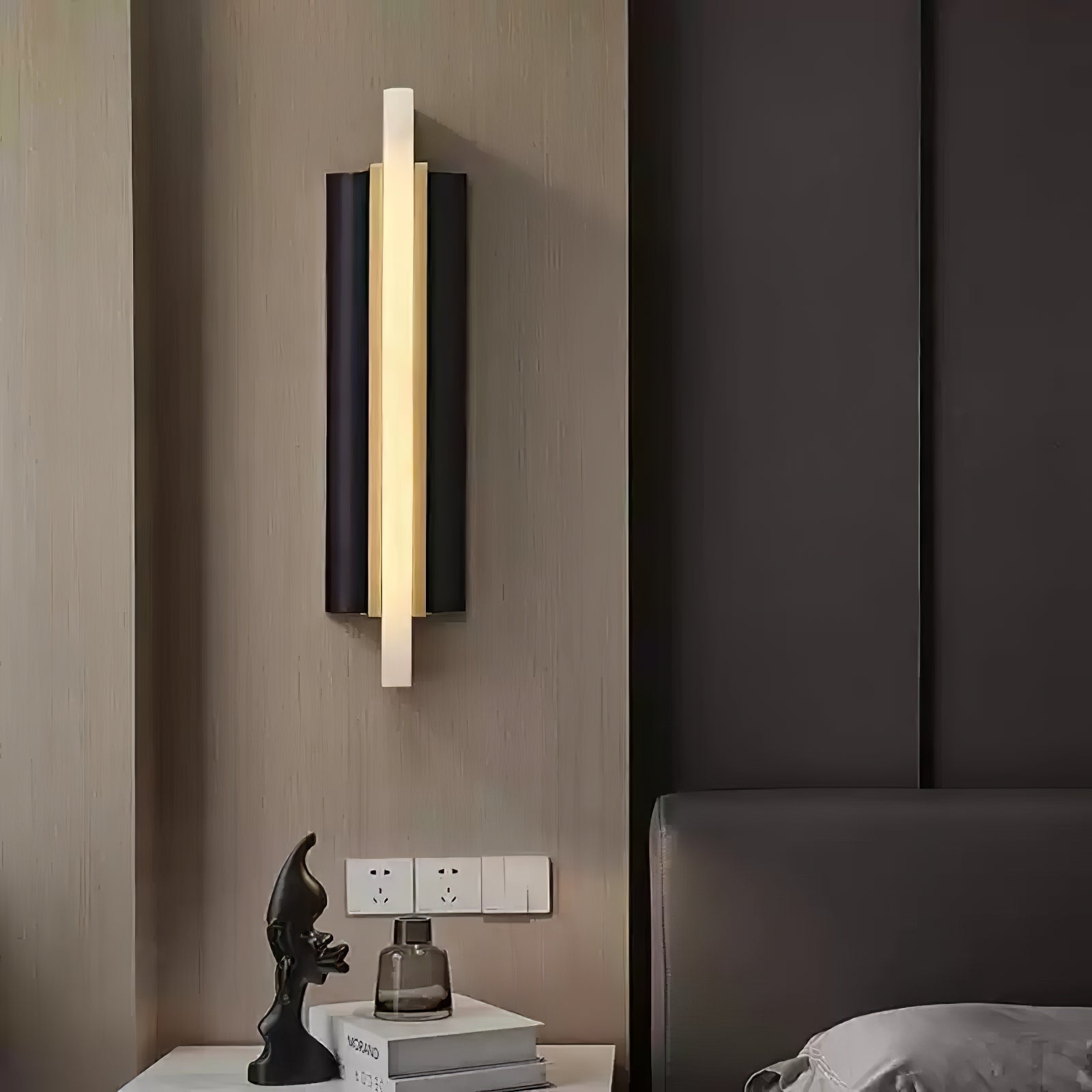 The light lit on a wood-panelled bedroom wall, above a nightstand with a figurine.