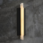 The light lit against a textured concrete wall, its alabaster blade glowing warm.