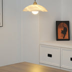 Nerea pendant switched on in the same white alcove, warm light spilling onto the wooden floor.