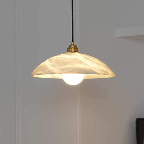Alabaster dome pendant lit against white panelling, its globe bulb visible below the rim.