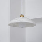 Alabaster dome pendant light with brass fitting in a modern interior