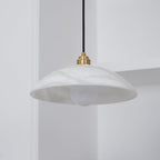 Angled unlit view into the Ritta pendant's dome, showing the smooth interior and globe bulb.