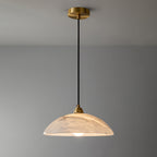 Nerea pendant lit and shown full length, brass canopy at the ceiling above a long black cord.
