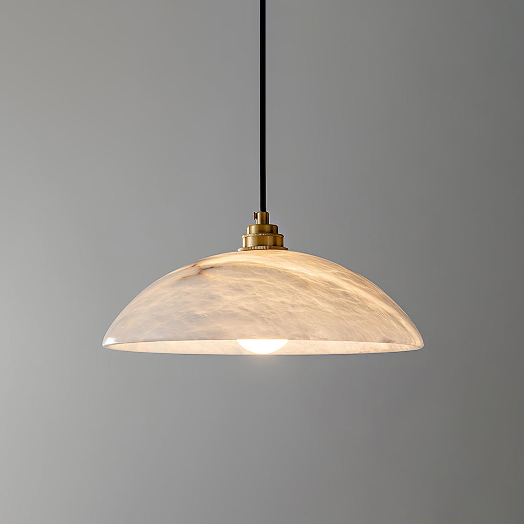 White alabaster pendant light glowing softly above a dining table