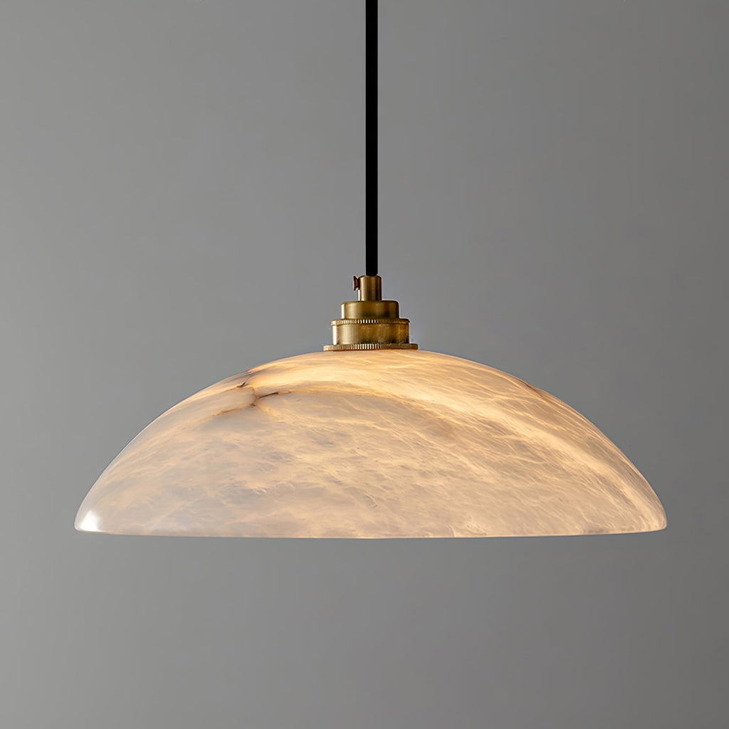Brass and alabaster dome pendant casting a warm inviting glow