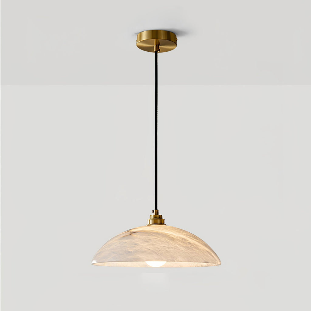Brass and alabaster dome pendant casting a warm mineral glow