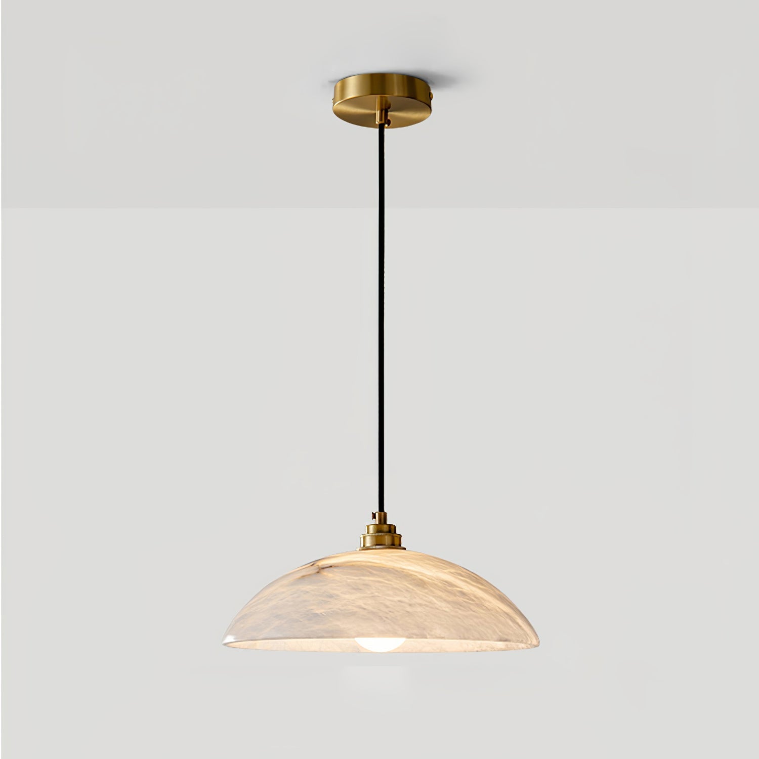 Brass and alabaster dome pendant casting a warm mineral glow