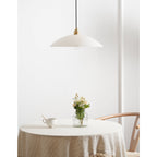 The unlit Nerea pendant over a round table dressed in cream linen, seen from further back.