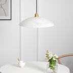 Brass and alabaster dome pendant light glowing in a styled space
