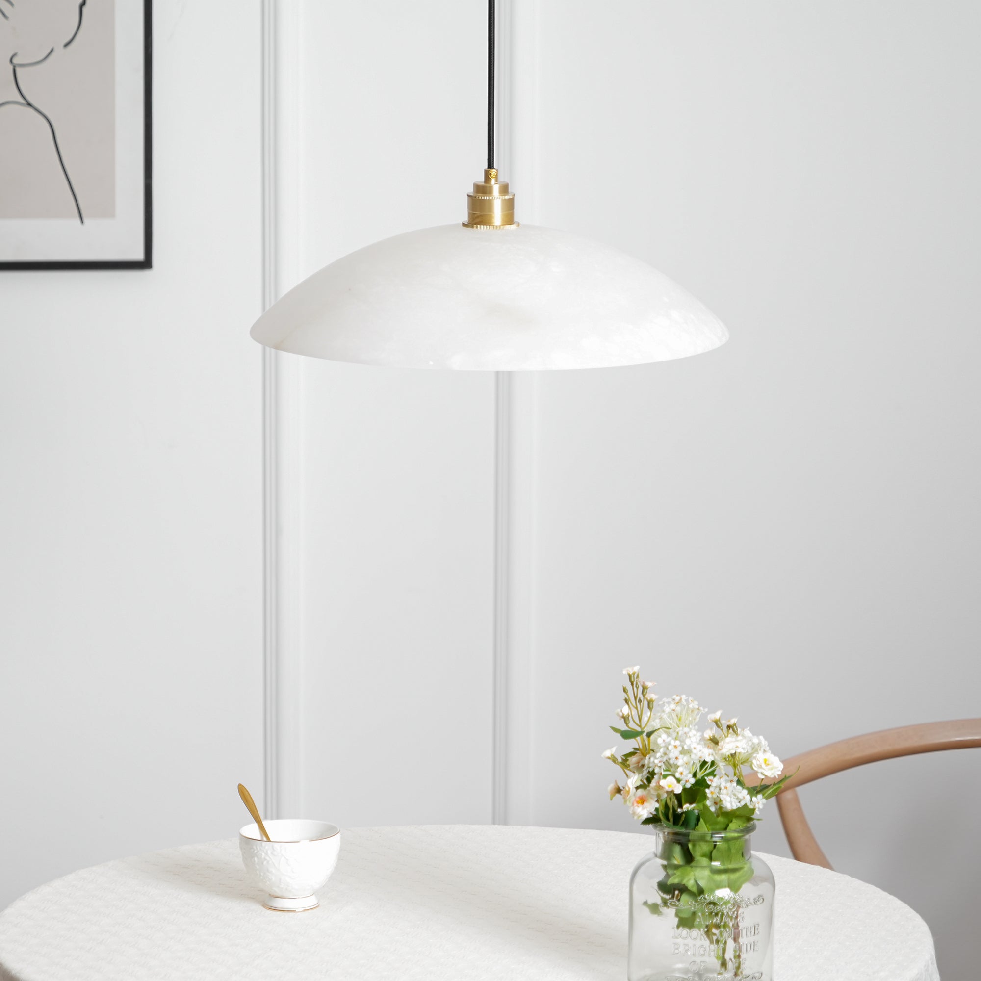 Brass and alabaster dome pendant light glowing in a styled space