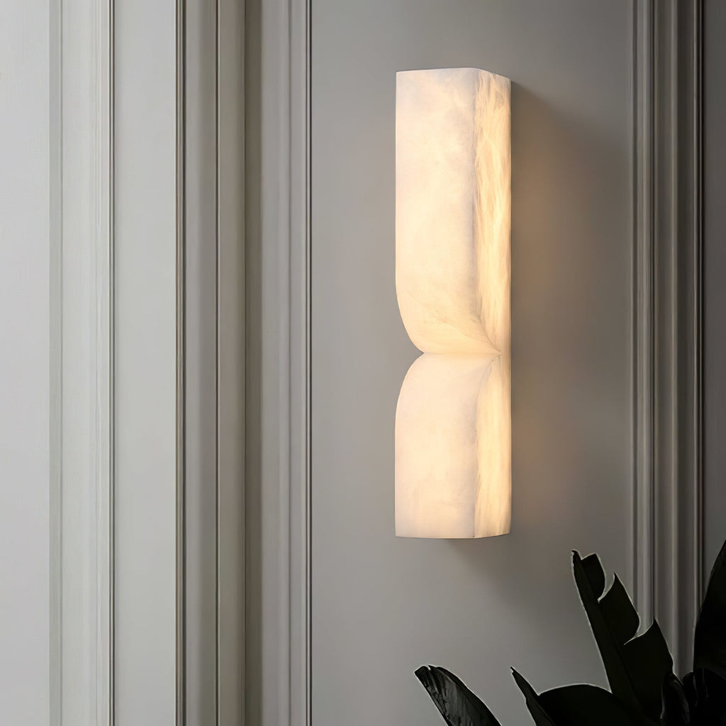 Carved alabaster wall light with gold finish and soft warm glow