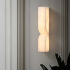 Carved alabaster wall light with gold finish and soft warm glow