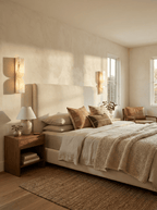 White alabaster wall sconce with warm glow beside neutral decor