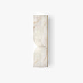 Solid carved alabaster wall sconce glowing warmly on an interior wall