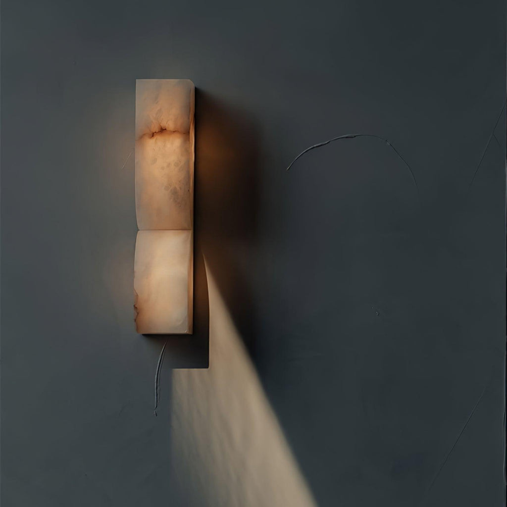 Sculptural carved alabaster sconce casting a warm gentle glow