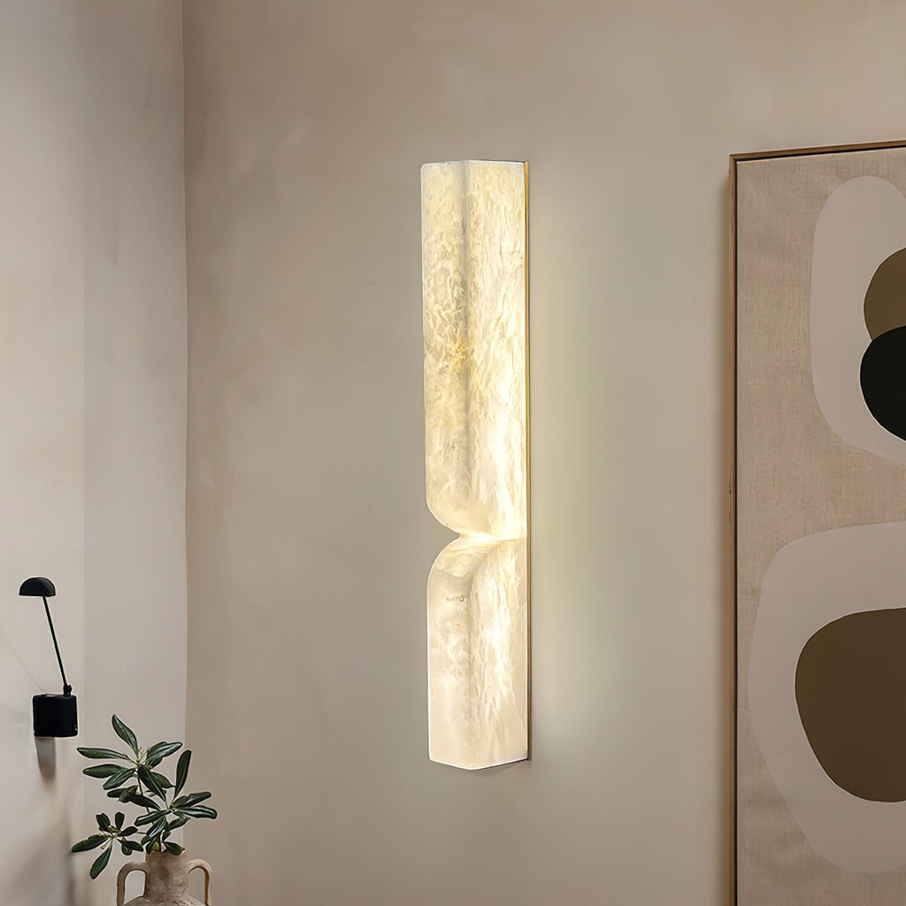 Carved alabaster wall light with warm ambient glow in a room