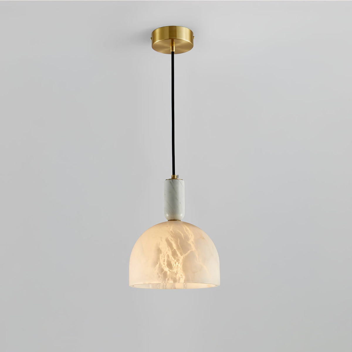 Clérachic alabaster pendant light on a plain light-grey background, another full studio view of the lit dome shade.