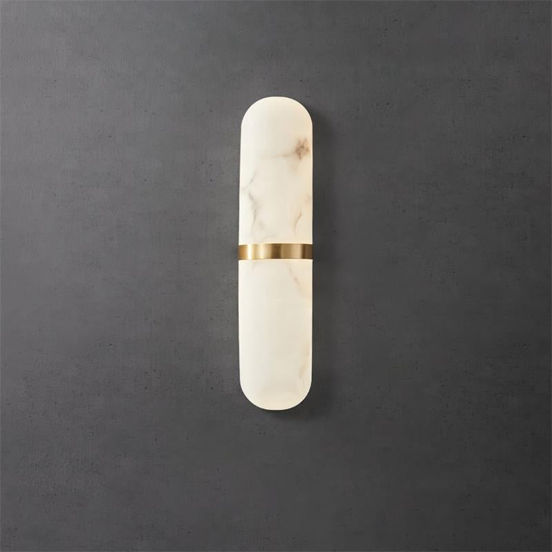 Clérachic ostruvyd alabaster wall lamp in the slim size, brass centre band, unlit on a dark concrete wall