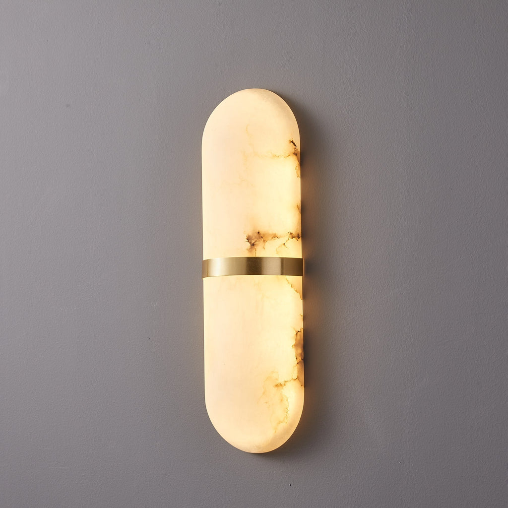 Clérachic close three-quarter view of the lit alabaster shade, brass band and warm glow along its edge