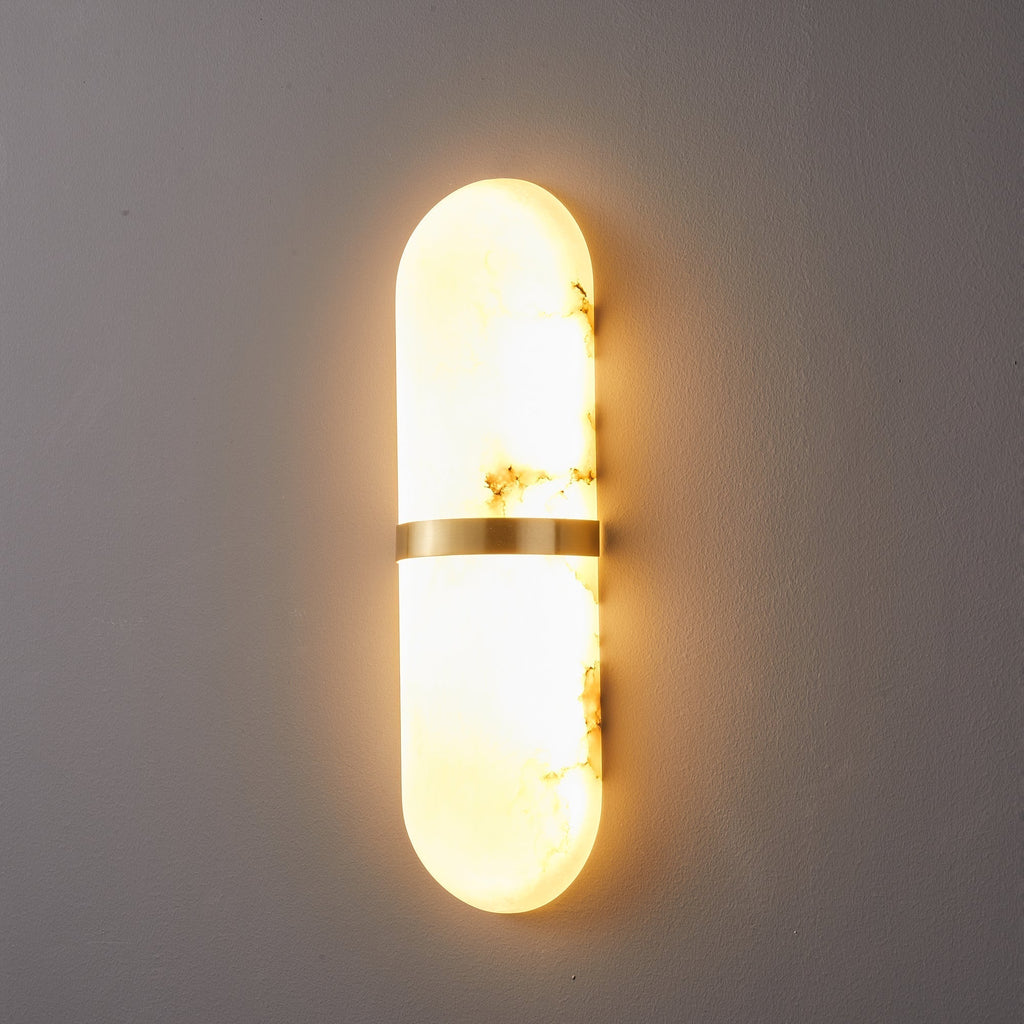 Clérachic side-angle view of the lit lamp, showing how the alabaster shade stands off the wall