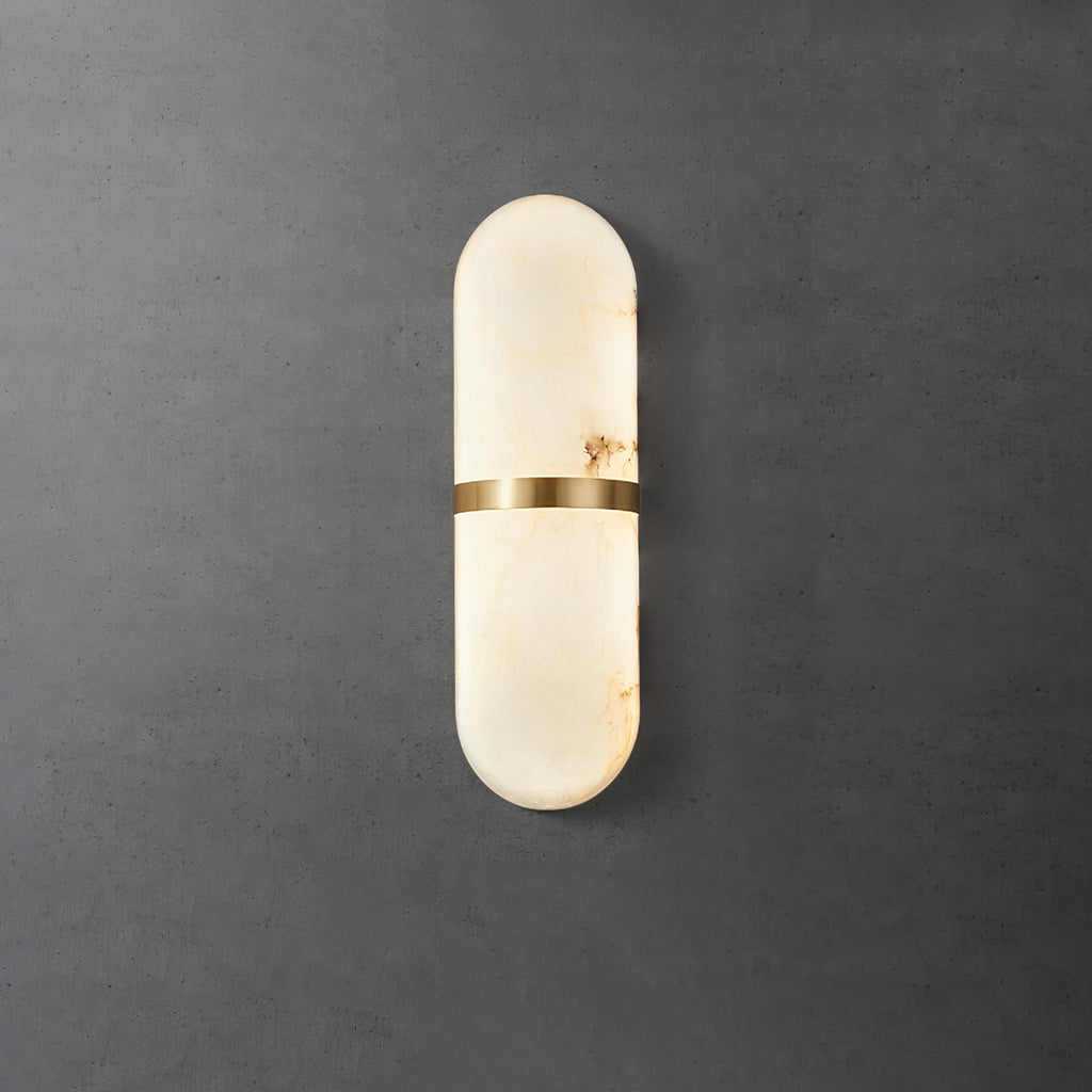 Clérachic brass-banded alabaster wall lamp on a dark concrete wall, warm amber veins visible in the stone