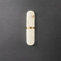 Clérachic front view of the slim brass-banded alabaster wall lamp, dark grey concrete backdrop, light off