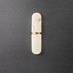 Clérachic front view of the slim brass-banded alabaster wall lamp, dark grey concrete backdrop, light off