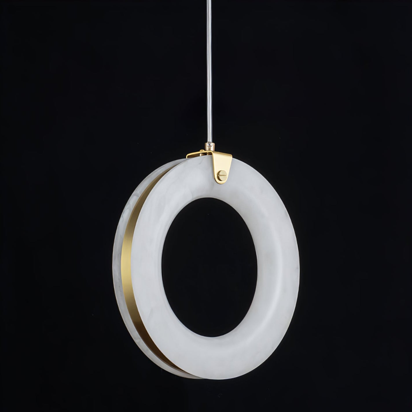 Three-quarter view of the unlit alabaster ring, brass disc behind the stone and gold clamp on top