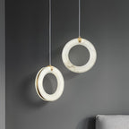 Two unlit alabaster rings showing the natural stone veining and the slim brass band behind
