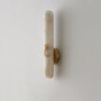The same sconce unlit on white, showing the rust-toned veining running through the alabaster.