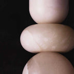 Macro crop of the pendant's cream alabaster forms against black, showing the seams where sections meet