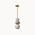 Full alabaster totem pendant with brass canopy and long suspension rod, shown unlit on a white background