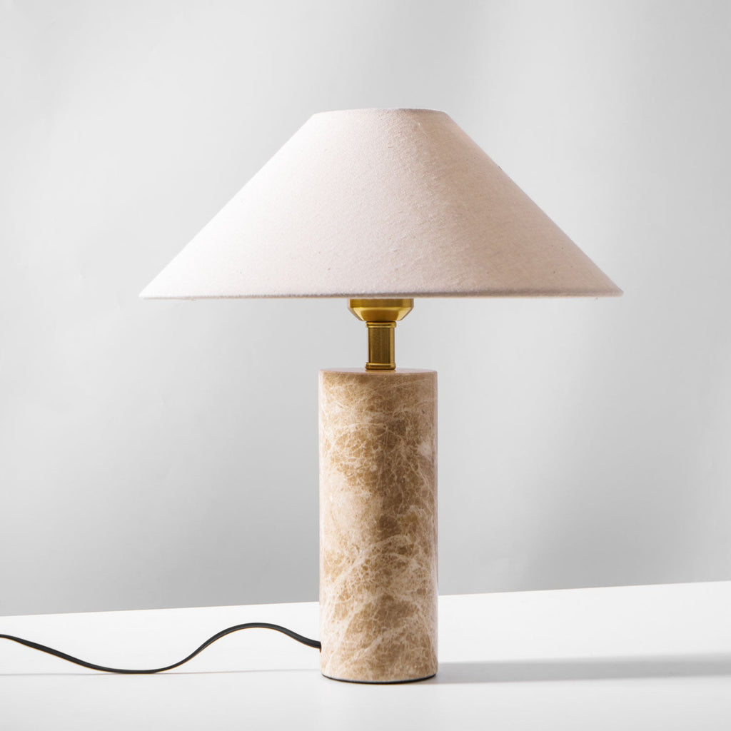 The Clérachic table lamp on a plain background, its beige shade shown pale and unlit with the cord trailing below.