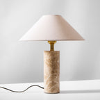 The Clérachic table lamp on a plain background, its beige shade shown pale and unlit with the cord trailing below.