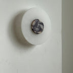 Clérachic side angle of the unlit Rauduvyi wall lamp showing how shallow the alabaster plate sits on the wall
