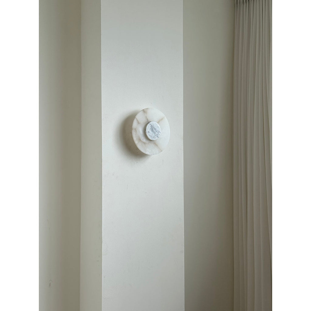 Clérachic rauduvyi wall lamp switched off on a pale wall pier next to a pleated floor-length curtain
