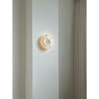 Clérachic lit Rauduvyi wall lamp on an interior wall, its glow reflecting softly onto the plaster around it