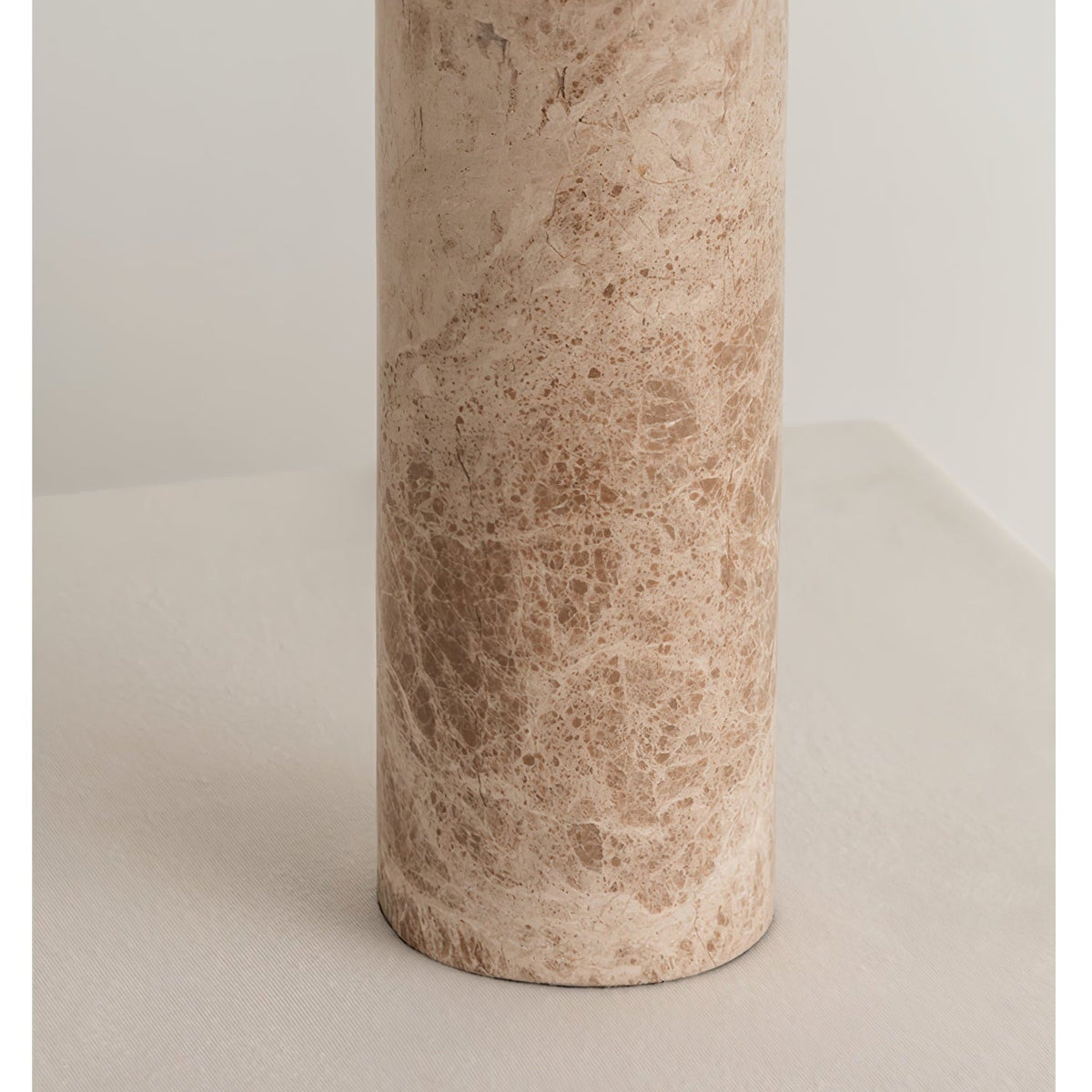 Close-up of the marble column alone, showing the Clérachic table lamp base's warm veining with no shade in view.
