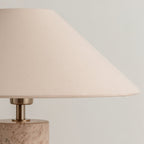 Close-up from below of the Clérachic table lamp's fabric shade, showing its woven texture and the brass neck.