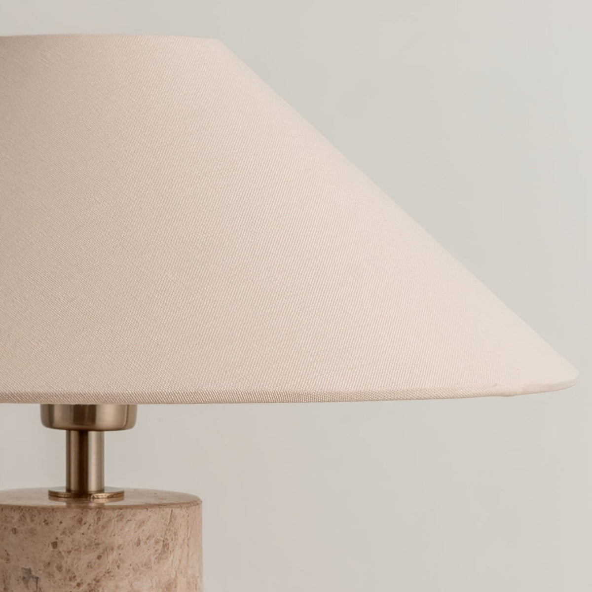 Close-up from below of the Clérachic table lamp's fabric shade, showing its woven texture and the brass neck.