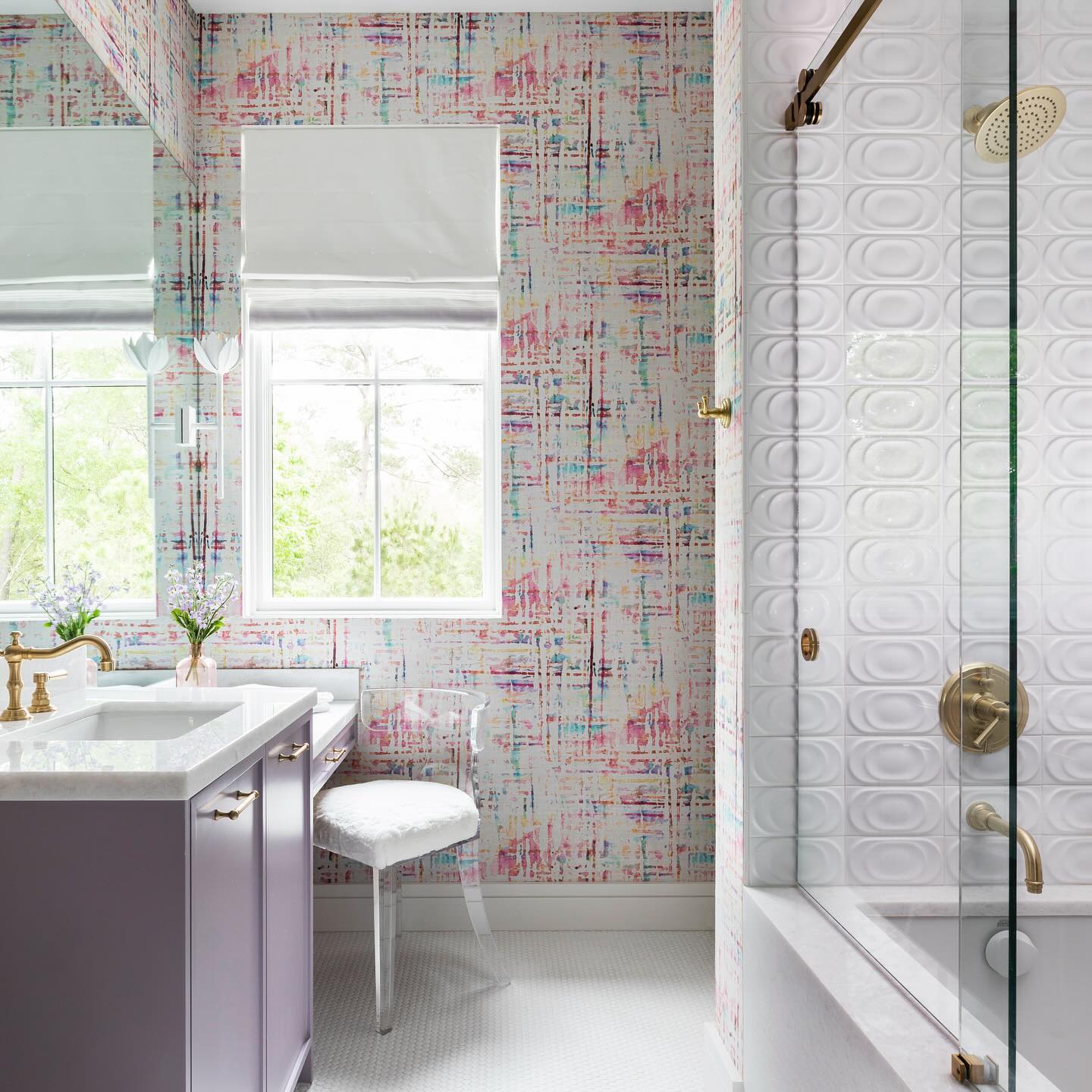 White Kristy sconces flanking the mirror in a colourful bathroom with a lilac vanity and brass taps.
