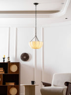 Cotton pendant light shown lit over a dining setting