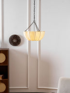 Cotton pendant light with black frame lit above a sofa