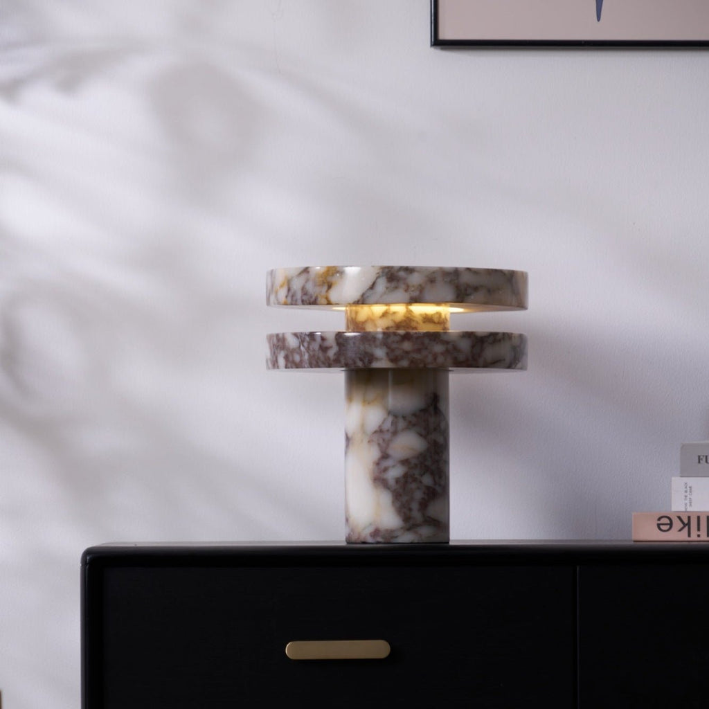 Vertical crop of the lit Clérachic lamp on the dresser, the drawer and brass pull visible directly beneath its base.